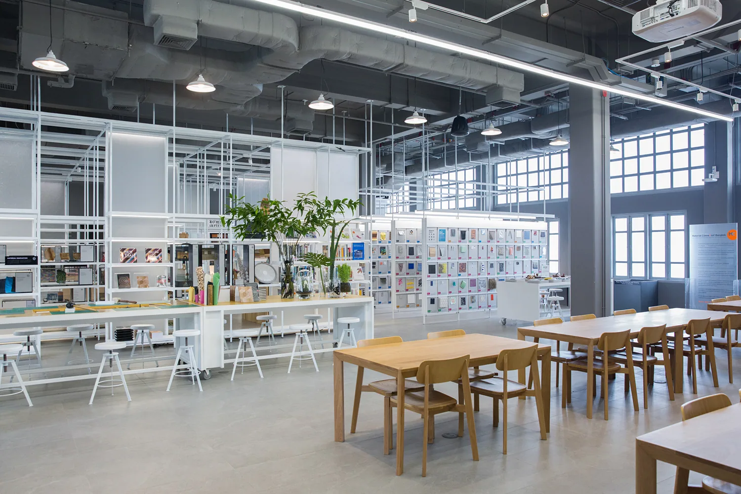 TCDC reading room with long communal desks, bookshelves, and soft natural light